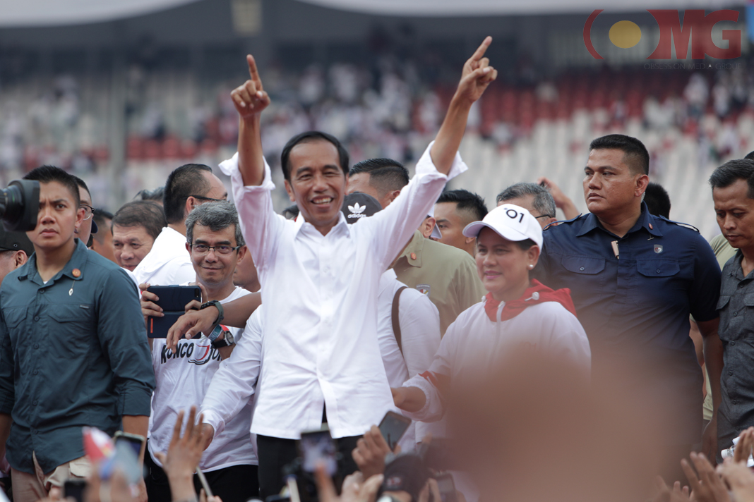 Capres nomor urut 01 Joko Widodo didampingi oleh istrinya saat menyapa pendukungnya di acara Konser Putih Bersatu di Stadion Utama Gelora Bung Karno, Senayan, Jakarta